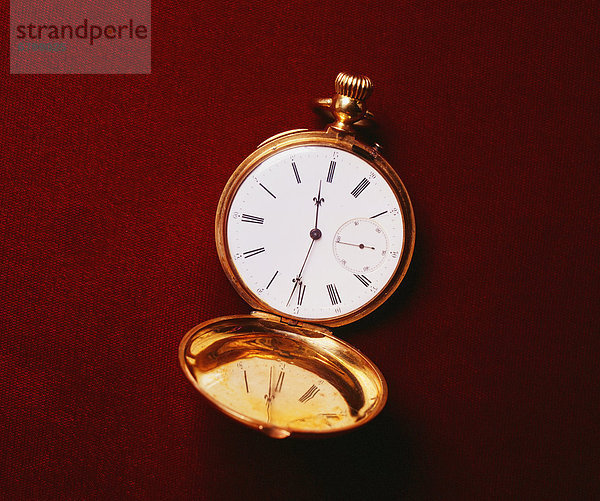 Image of gold pocket watch  laying on dark background