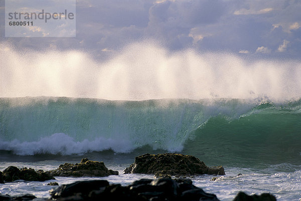 Wave crashes on rocky shoreline  mist on wave B1445