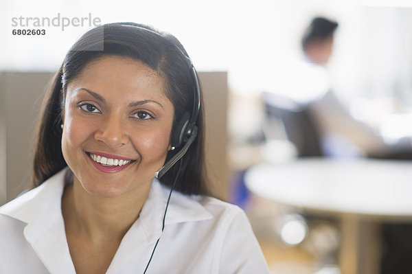 Businesswoman with headset  businessman in background