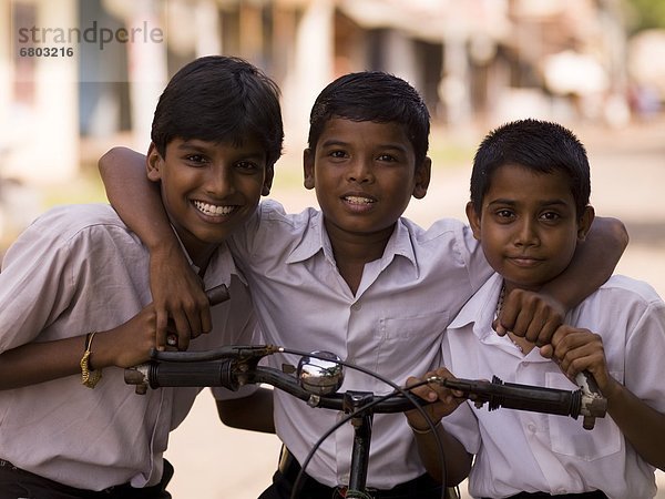 sitzend  Portrait  lächeln  Junge - Person  Blick in die Kamera  Fahrrad  Rad  Indien  Kerala