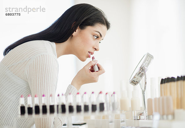 Young Woman applying lipstick