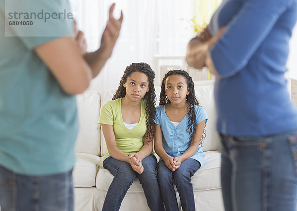 Parents quarreling  with daughters (10-13) in background