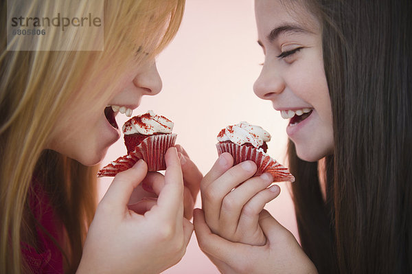hoch  oben  nahe  2  Mädchen  essen  essend  isst  cupcake