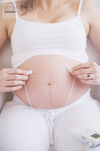 Frau  halten  Schwangerschaft  Ohrhörer