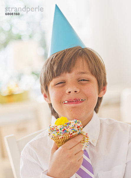 Portrait  Junge - Person  Party  Hut  essen  essend  isst  cupcake  10-11 Jahre  10 bis 11 Jahre