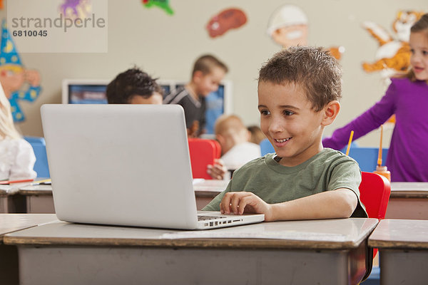 Children (4-5  6-7) at school using laptop