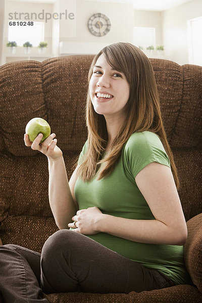 sitzend  Portrait  Frau  Couch  Schwangerschaft  Apfel  essen  essend  isst