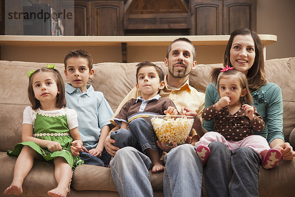sitzend  sehen  frontal  Fernsehen  Ansicht  Couch  5-6 Jahre  5 bis 6 Jahre  5-9 Jahre  5 bis 9 Jahre  essen  essend  isst  Popcorn
