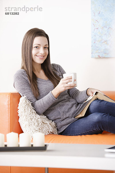 junge Frau junge Frauen Couch lächeln vorlesen
