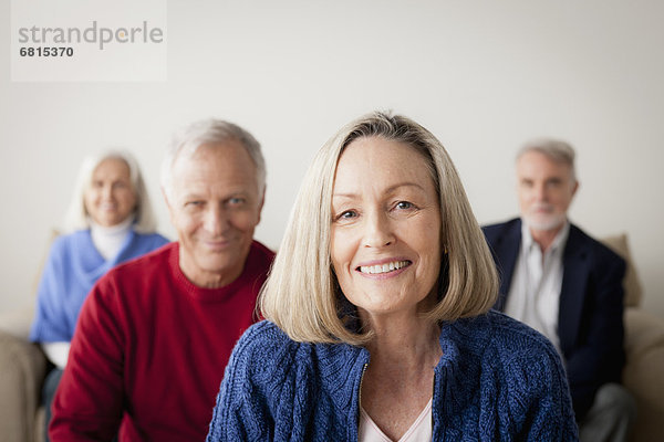 Two senior couples on sofa  smiling woman in foreground