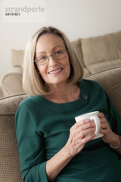 sitzend Portrait Frau Couch Becher lächeln halten