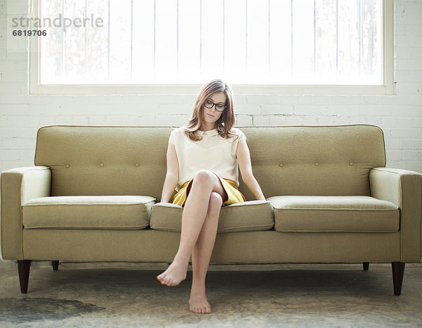 Junge Frau sitzt auf dem Sofa