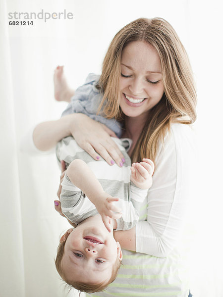 verkehrt herum  Portrait  Frau  umarmen  Junge - Person  jung  Baby