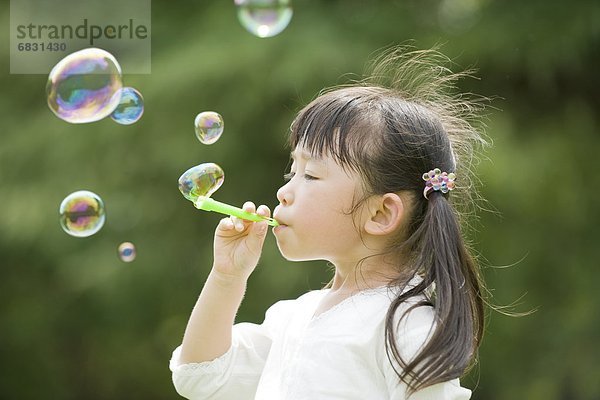 Ein Girl blowing bubbles
