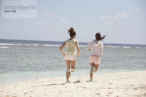 Young women jogging on beach  Guam USA