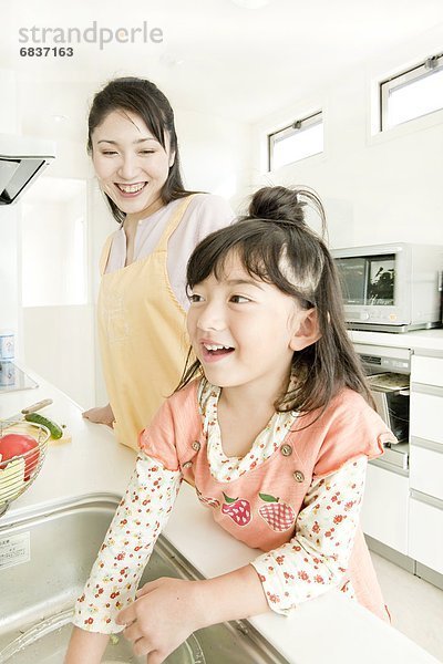 Mutter und Tochter in Küche kochen