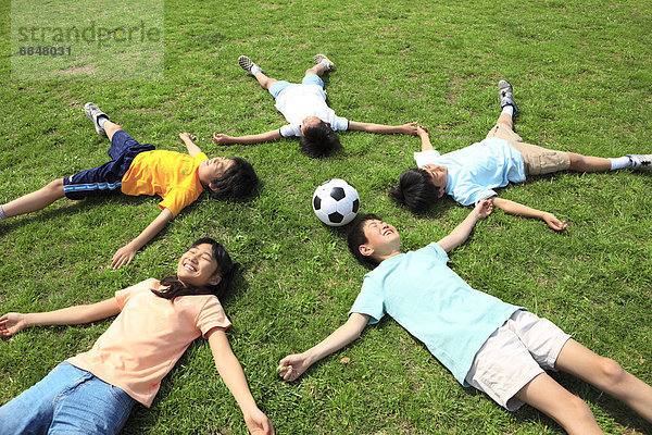 liegend  liegen  liegt  liegendes  liegender  liegende  daliegen  Fröhlichkeit  Feld  Fußball  Ball Spielzeug  Tokyo  Hauptstadt  Japan