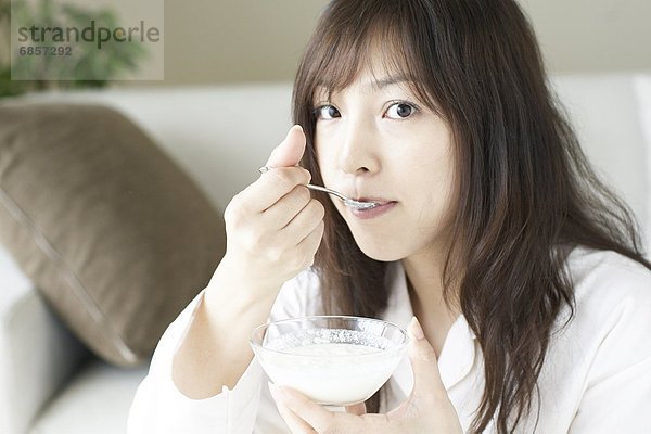 junge Frau junge Frauen Joghurt essen essend isst Frühstück