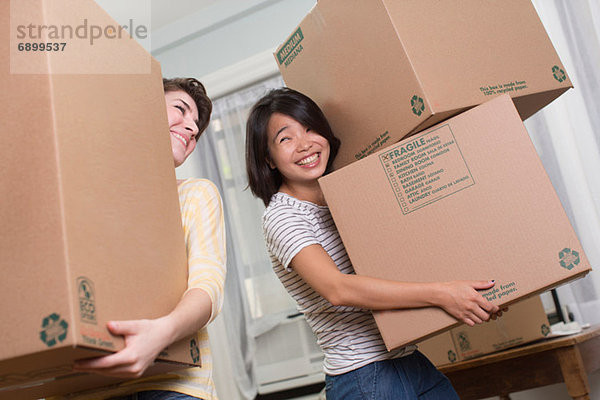 Zwei junge Frauen bewegen Kisten