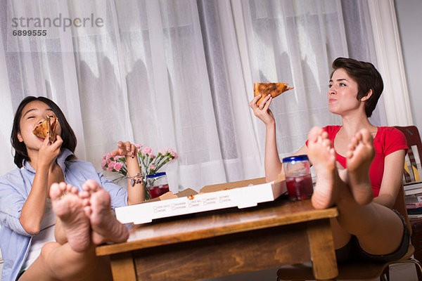 Freundinnen genießen Pizza zum Mitnehmen