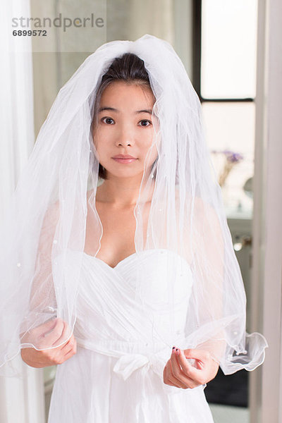 Junge Frau im Brautkleid mit Schleier