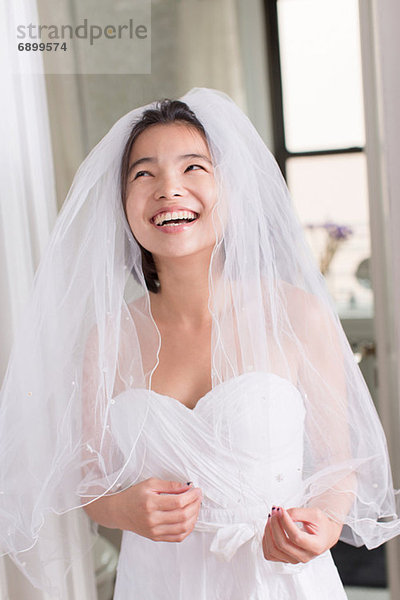 Junge Frau im Brautkleid und lachend