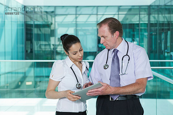 Ärzte diskutieren über Krankenakten auf digitalem Tablett