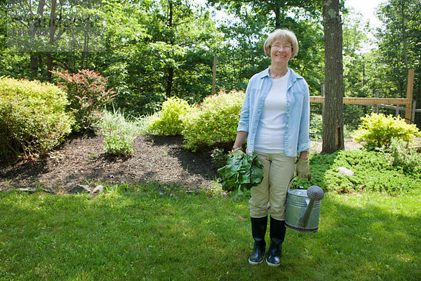 Frau mit Gießkanne und Rote Beete im Garten