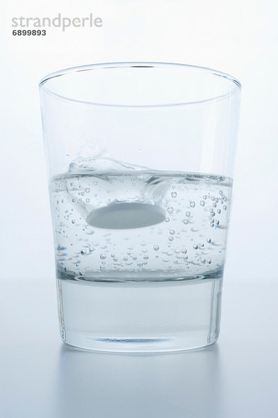 Pille im Glas Wasser