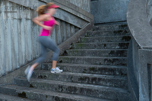 Junge Frau rennt die Treppe hinauf  Bewegungsunschärfe