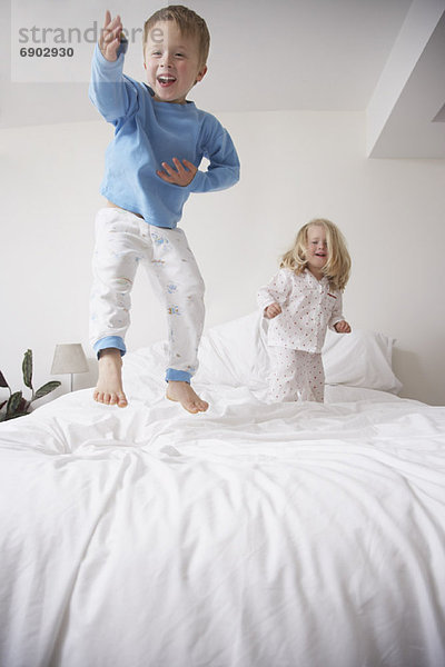 Kinder springen auf Bett