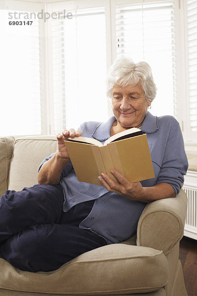 sitzend Senior Senioren Frau Couch Buch Taschenbuch vorlesen