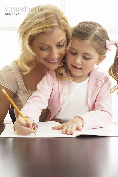 Mutter hilft Tochter bei den Hausaufgaben