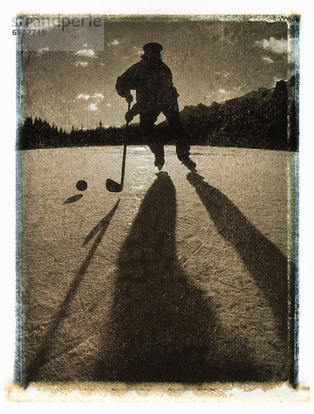 Außenaufnahme  Mann  Silhouette  Canmore  Alberta  Kanada  Hockey  freie Natur  spielen