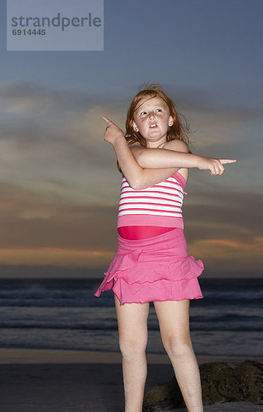 Girl on the Beach  Pointing In Different Directions