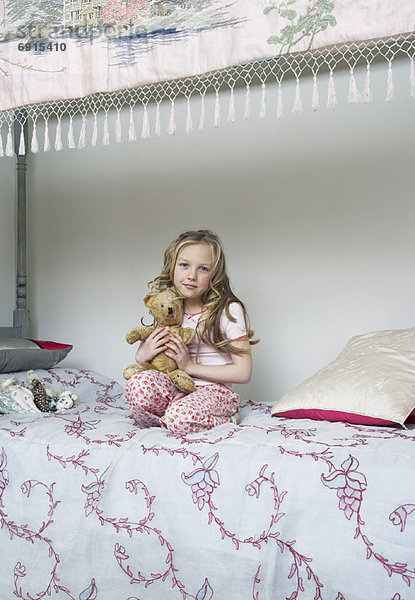 Girl Sitting on Bed  Holding Teddy Bear