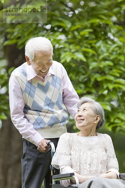 Senior  Senioren  Mann  Ehefrau  schieben  Rollstuhl