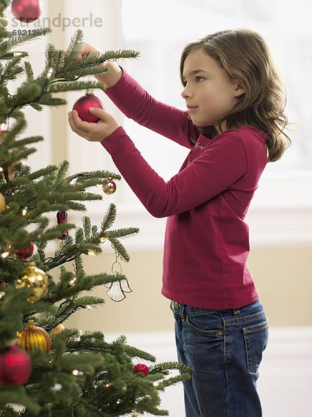 Mädchen dekorieren Weihnachtsbaum