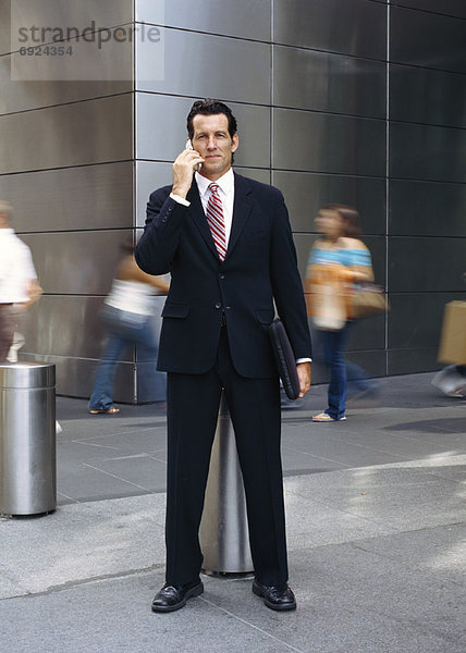 Portrait of Businessman Standing Outdoors  Talking On Cellular Phone