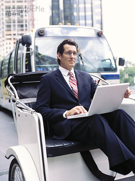 Businessman With Laptop Computer  Sitting in Rickshaw