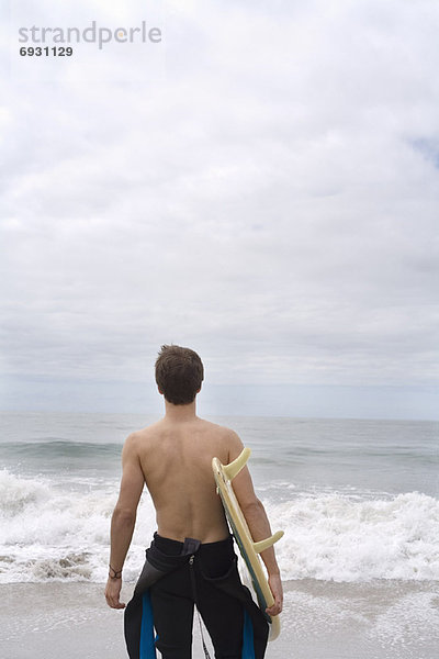 Mann  hält Surfboard