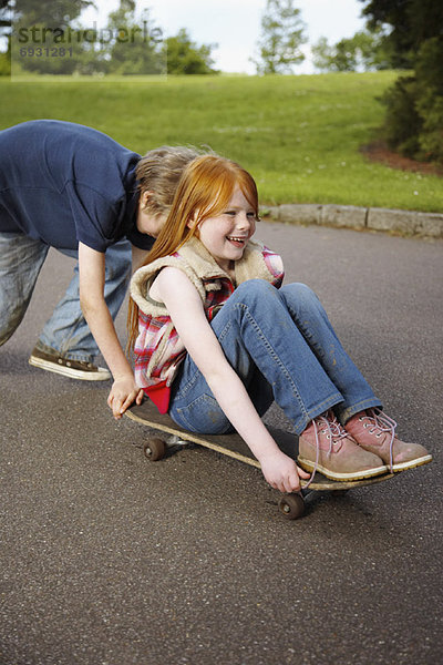 schieben  Junge - Person  Skateboard  Mädchen