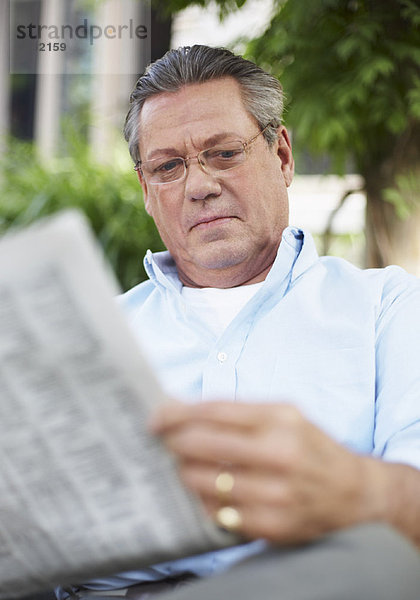 Portrait Mann Zeitung vorlesen