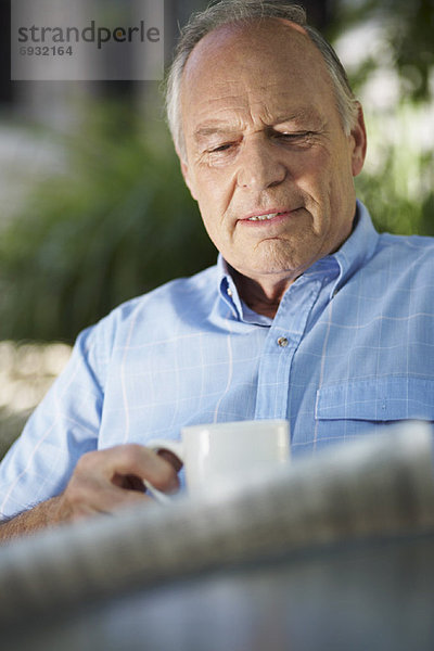 Mann trinken Kaffee Zeitung vorlesen