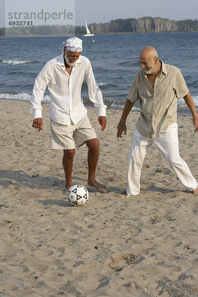 Mann Strand Fußball spielen
