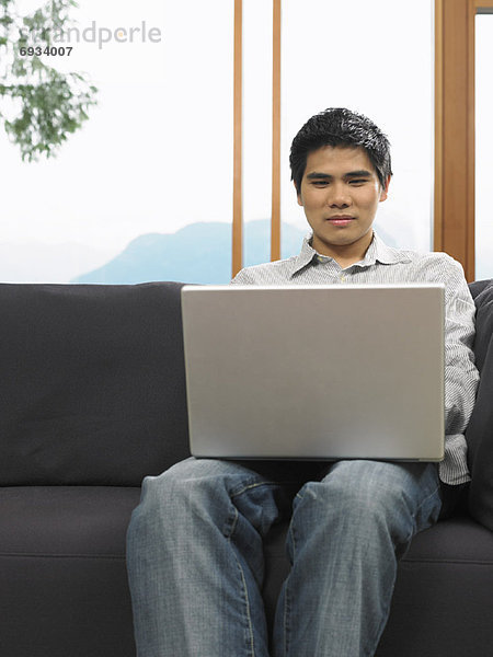 sitzend benutzen Mann Computer Notebook Couch