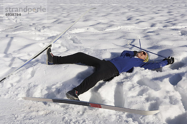 Man Wearing Skis  Lying in Snow
