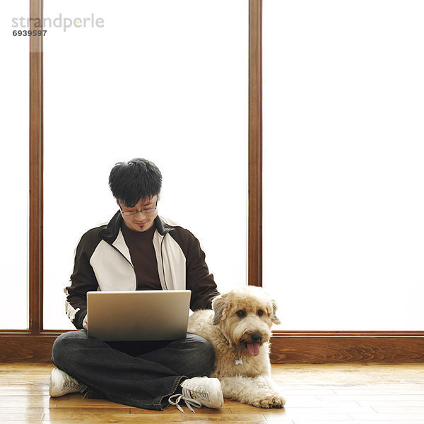 Mann sitzen auf Boden mit Laptop