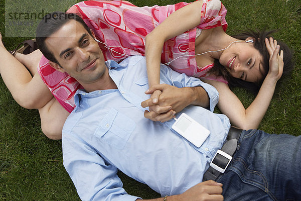 Couple Lying on Grass  Listening to Mp3 Player