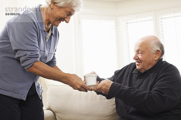 Senior Senioren Frau Mann geben Getränk